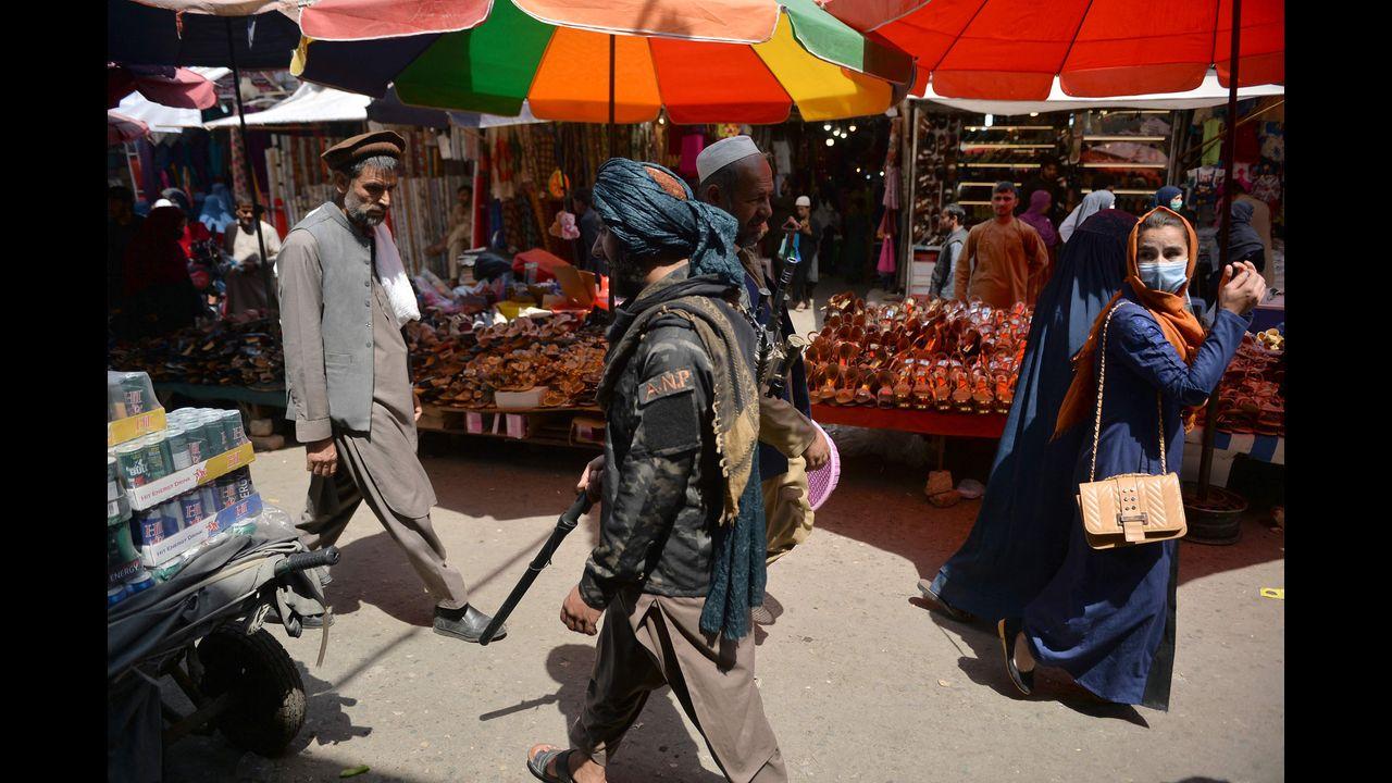 A Taliban fighter (C) walks past shoppers along Mandawi market in Kabul on September 1, a day after the US pulled all its troops out of the country to end a brutal 20-year war -- one that started and ended with the hardline Islamist in power. Pic/AFP